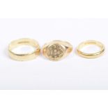 A 22k gold band Together with, an 18k gold band, and a yellow metal monogrammed signet ring,