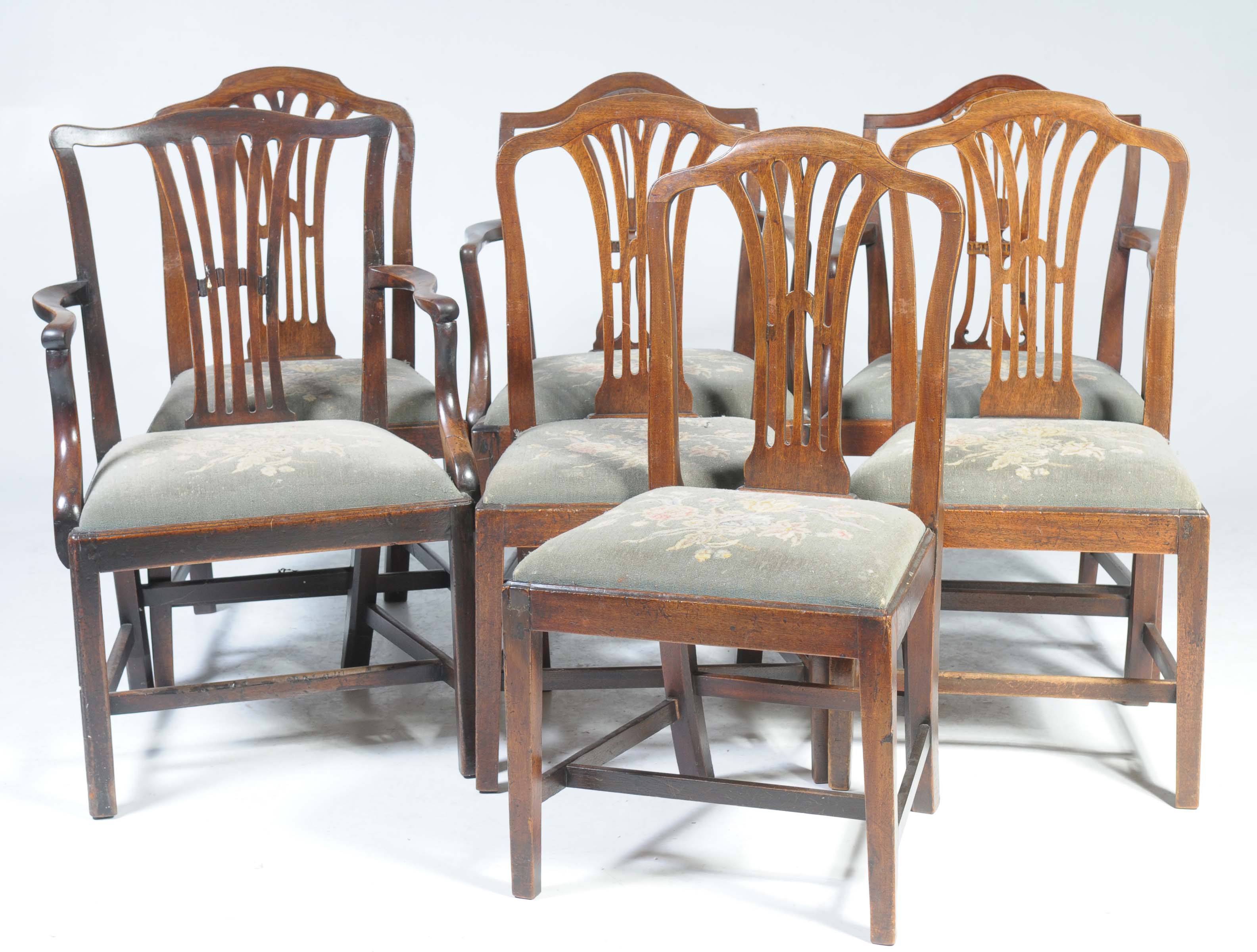 A matched set of seven 19th Century Hepplewhite style dining chairs Each with a pierced splat back