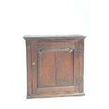 An 18th Century oak spice cupboard With a single panelled cupboard door enclosing two shelves,