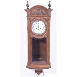 An early 20th Century walnut cased wall clock With an arched pediment above a 7" enamel dial