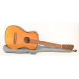 A cased acoustic guitar with a stained beech wood back, 20th century.