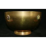 An Arts & Crafts brass pedestal bowl Of circular form having four enamelled roses, height 12cm,