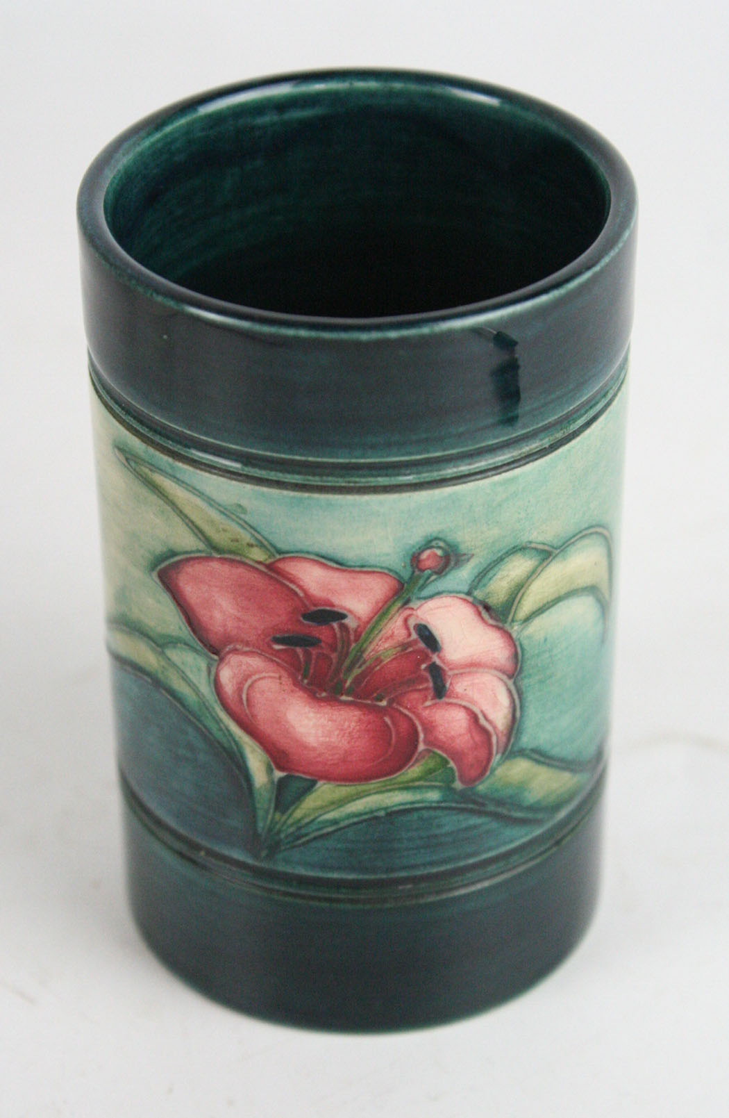 A Walter Moorcroft cylindrical vase Decorated in the 'Lily' pattern on a green and blue ground,