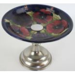 A Walter Moorcroft tazza Decorated in the 'Pansy' pattern on a blue ground, raised on chrome stand,