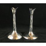 A pair of contemporary hallmarked silver candlesticks Each modelled with open flower buds raised on