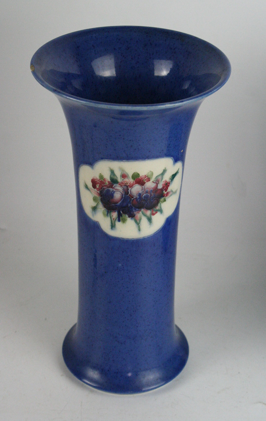 A William Moorcroft vase of trumpet form Decorated in the 'Fruit and Flowers' pattern on a powder