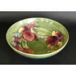 A Walter Moorcroft bowl of circular form Decorated in the 'Orchid' pattern on a green ground,
