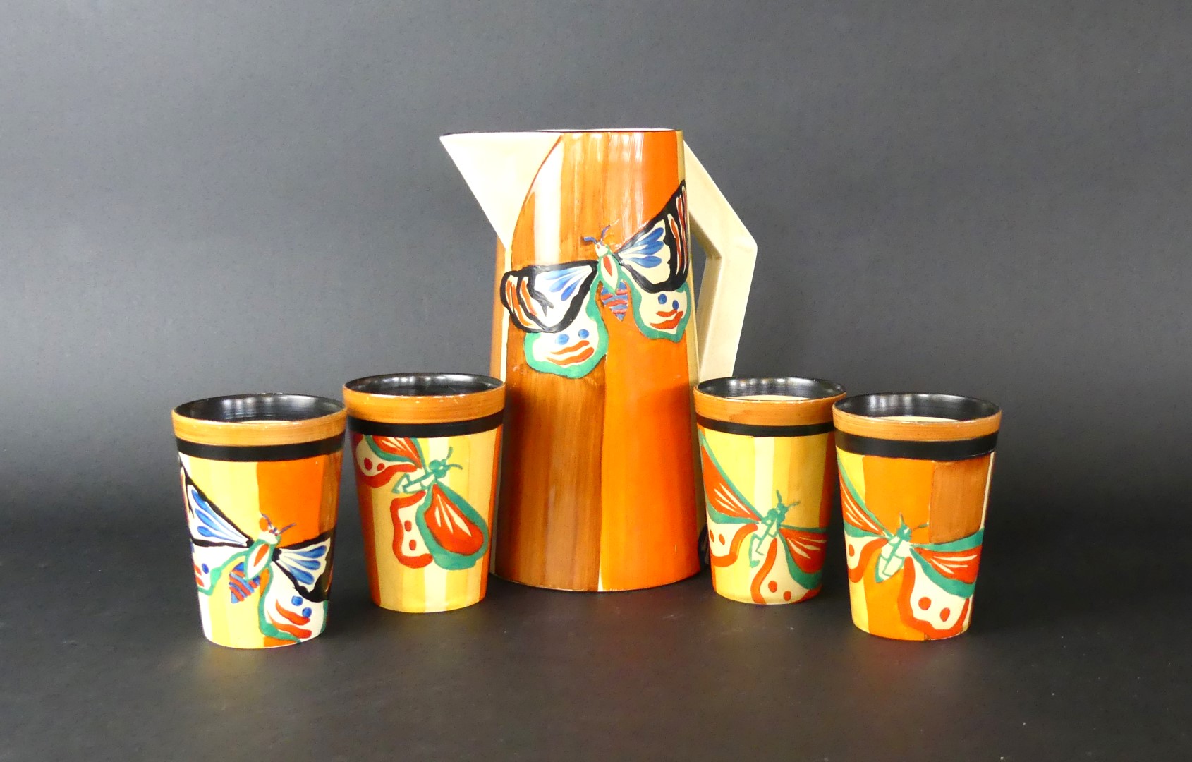 A rare Clarice Cliff Fantasque drinking set Decorated in the 'Butterfly' pattern, circa 1929-1930,