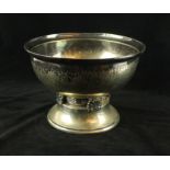 An Arts & Crafts silver-plated bowl Having planished decoration and raised on floral supports,