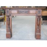An early 20th Century oak fire surround With a rectangular shelf above a central carved panel,