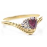 A ruby and diamond ring The pear shaped ruby, flanked by diamonds, inside the shank stamped 850,