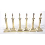 A set of six gilt metal table lamps Each with a square stepped base rising to a Corinthian column