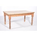 A rustic pine slab top kitchen table The stripped slab top raised on four ring turned baluster legs,