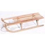 A German vintage wooden sledge Of typical form with curved lower rails and slatted top seat,