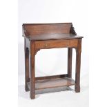 An early 20th Century oak hall table Having a galleried back above a rectangular top with canted