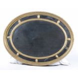 An early 20th Century oval giltwood mirror The inner slip section adorned with flower head designs