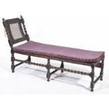 A late 19th early 20th Century carved oak day bed The adjustable rattan head support mounted on two