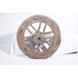 A large carved oak cart wheel Of typical form with twelve spoked interior and central terminal