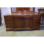 A reproduction mahogany breakfront sideboard Having a central sliding tray above a pair of cupboard