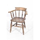 A late 19th early 20th Century elm and beech smokers elbow chair The outswept arms supported on