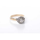 A diamond set cluster ring Centering a round brilliant-cut diamond to a vari-cut diamond surround,