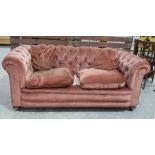 An early 20th Century pink valour Chesterfield type settee With a deep set padded and button back
