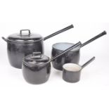 A graduated set of vintage French enamelled saucepans The black enamel pots adorned with domed lids