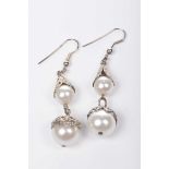 A pair of imitation pearl ear pendants Of graduated form, with pierced white metal detail,