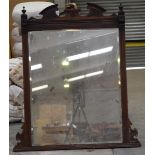 A late Victorian oak framed over mantel mirror With a shaped pediment flanked by two urn shaped