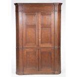 A George III oak flat front free standing corner cupboard The upper cabinet with a moulded cornice