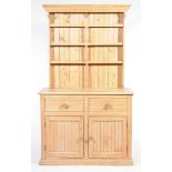 A pine kitchen dresser The high back with a moulded cornice above three shelves each centered with