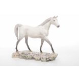 A Royal Doulton for Beswick figure of a Dapple grey horse Modelled in striding position raised on a