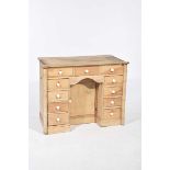 A 19th Century pine kneehole dressing table With an arrangement of eleven small drawers embracing a