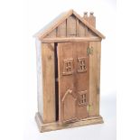 A rustic carved hardwood house form cabinet The small scratch built cabinet of architectural form,