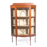 An Edwardian inlaid mahogany display cabinet Of angled bowfront form with a single glazed door