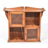 A late Victorian walnut wall cabinet Having two doors each carved with a geometric foliate design