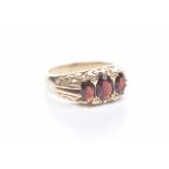 A garnet three stone ring To a 9k gold scroll mount, weight approx. 5.