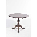 A Georgian mahogany circular tripod table The tilt top table raised upon a ring turned baluster