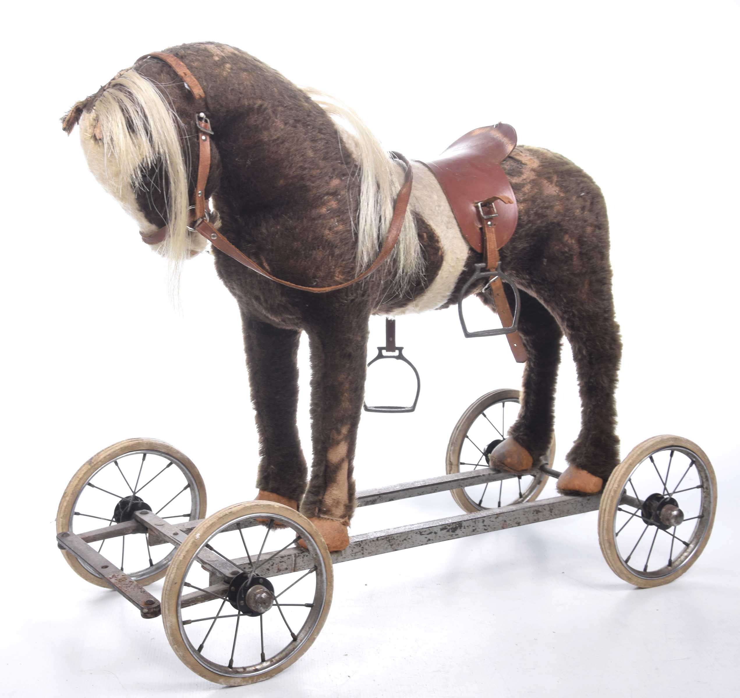 A vintage 1960's child's pull along toy The flush horse figure adorned with saddle mounted on a