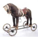 A vintage 1960's child's pull along toy The flush horse figure adorned with saddle mounted on a