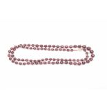 A garnet bead necklace Each bead of graduated form, interspaced with yellow metal beads,