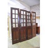 Two pairs of early 20th Century stained pine glazed doors Each door with eight glazed panels and