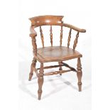 An early 20th Century stained beech smokers bow elbow chair The outswept elbow rail supported on