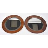 A pair of early 20th Century framed mahogany mirrors Each of bevelled rounded form,