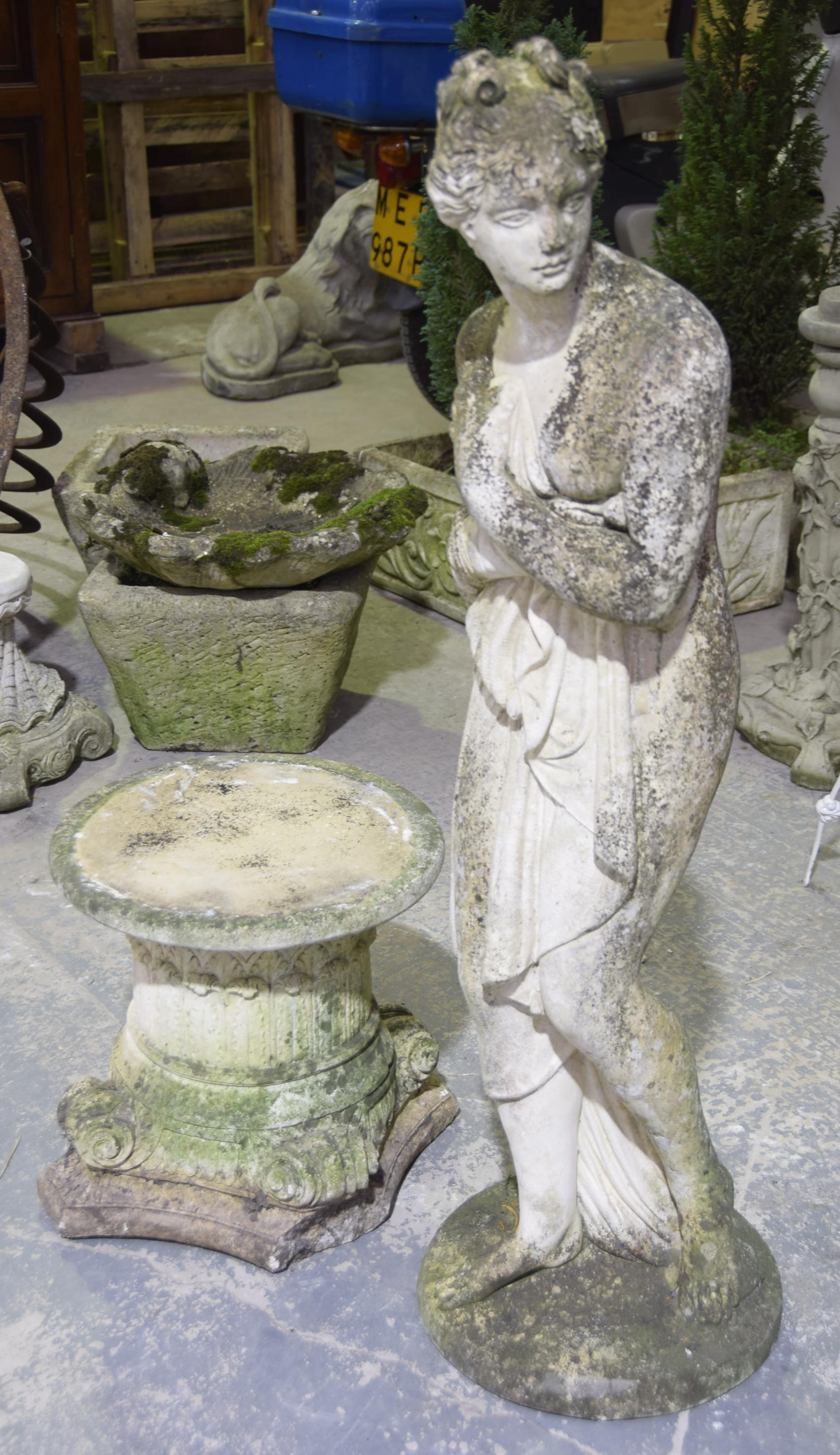 A reconstituted stone figure of a classical female after the antique The figure with loral garland