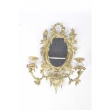 A French Girandole style gilt metal wall mirror The oval mirror plate adorned with acanthus and