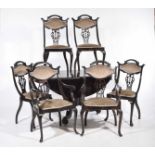 An early 20th Century stained hardwood drop leaf pedestal table and six chairs The circular drop