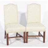 A pair of padded highback dining chairs by Sinclair & Mathews Each chair with an arched padded back