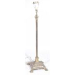 An early 20th Century gilt metal standard lamp The stepped square base raised on four paw feet