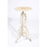 A white painted cast iron occasional table The scrolling tripod base raised from three hooves